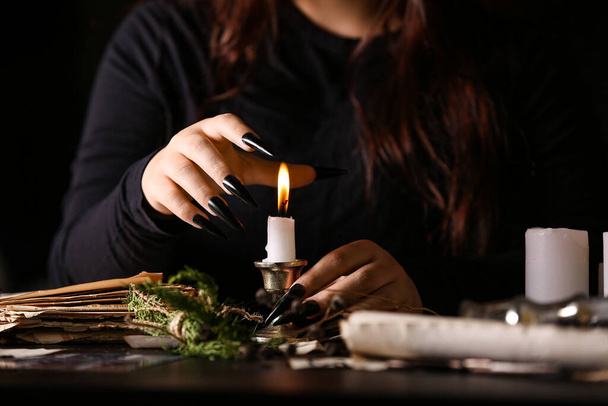 Bruxa com vela acesa na mesa escura, close-up - Foto, Imagem