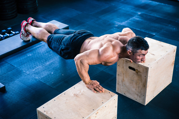 Muscular man doing push ups on fit box - Foto, afbeelding
