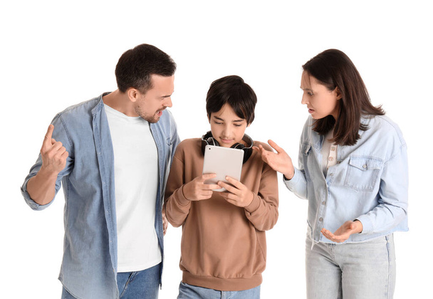 タブレットコンピュータと彼の主張する両親と白い背景の十代の少年. 家族問題コンセプト - 写真・画像