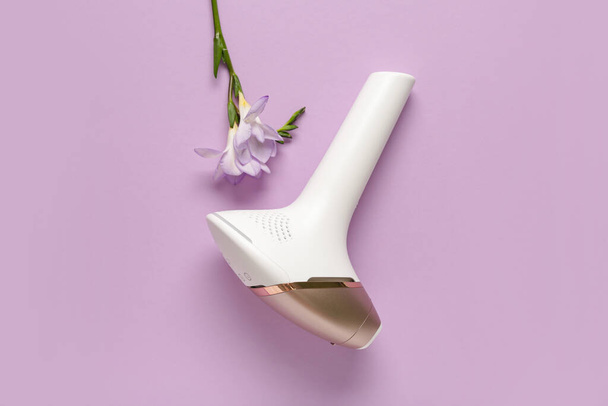 Fotoepiléptica moderna con hermosa flor sobre fondo púrpura - Foto, imagen