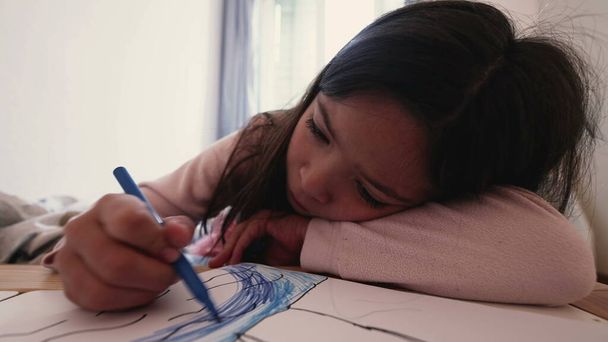 Kleines Mädchen zeichnet mit Malstift auf Papier, künstlerische Freizeit in der Kindheit. Kindersoloprogramm - Foto, Bild