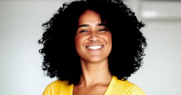 Een vrolijke zwarte latina close-up gezicht kijkt naar de camera glimlachend. Afro-Amerikaanse jonge vrouw portret en krullend haar met vriendelijke betrokkenheid - Video