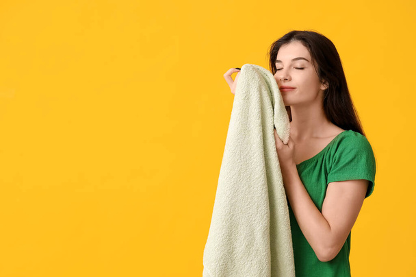 Beautiful young woman with clean towel on yellow background - Photo, Image