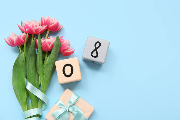 Bouquet di fiori di tulipano, confezione regalo e calendario a cubo con data della Giornata Internazionale della Donna sullo sfondo a colori - Foto, immagini