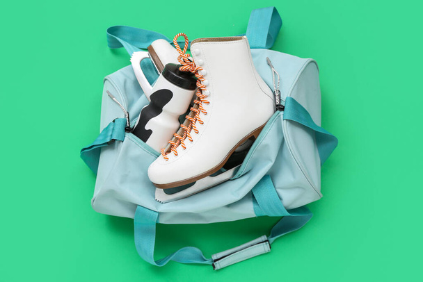 Αθλητική τσάντα με πατίνια και ακουστικά σε πράσινο φόντο - Φωτογραφία, εικόνα