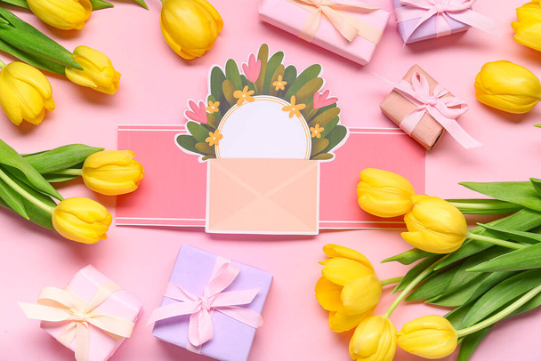 Cadeaudoosjes, gele tulpen en blanco wenskaart op roze achtergrond. Sluitingsdatum - Foto, afbeelding