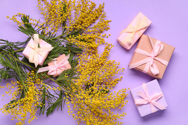Gift boxes and mimosa on lilac background. Top view - Photo, Image