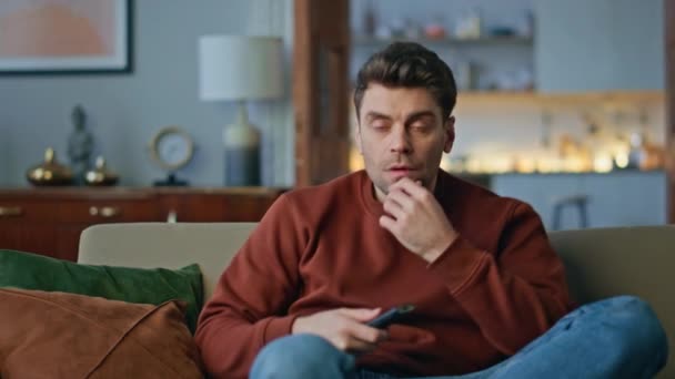 Interested man looking television football championship in modern apartment close up. Excited guy rejoicing goal watching sport game sitting couch. Emotional fan celebrating win favorite team at home. - Footage, Video