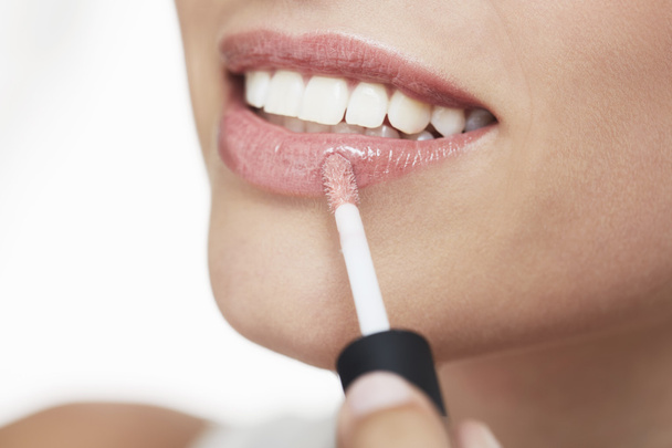 Woman applying lip gloss - Foto, imagen