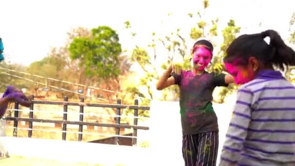 metraje de la chica india feliz jugando colores, sonriendo con colores en la cara de los niños asiáticos celebrando Holi - Imágenes, Vídeo