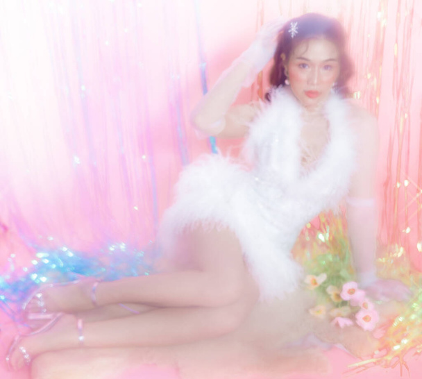Young Asian woman with a beautiful face wear glamour dress poses surround by a rainbow curtain party.  people, holidays, emotion and glamour concept. - Foto, immagini