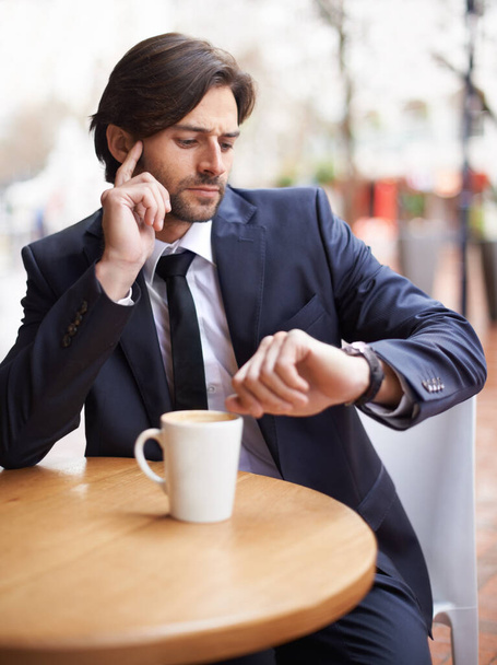 Late, cafe and businessman thinking of time, workplace and appointment for meeting in office. Male person, schedule and coffee on table in shop, employee or staff or corporate company with watch. - Foto, imagen