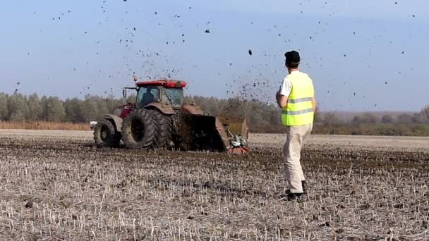 Tractor tira de una máquina que corta los canales en el campo
 - Imágenes, Vídeo