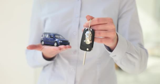 Car dealership employee offers keys and model of new car. Purchase rental or leasing of transport - Footage, Video