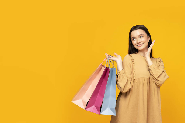 Uśmiechnięta atrakcyjna młoda kobieta z torbami na zakupy - Zdjęcie, obraz