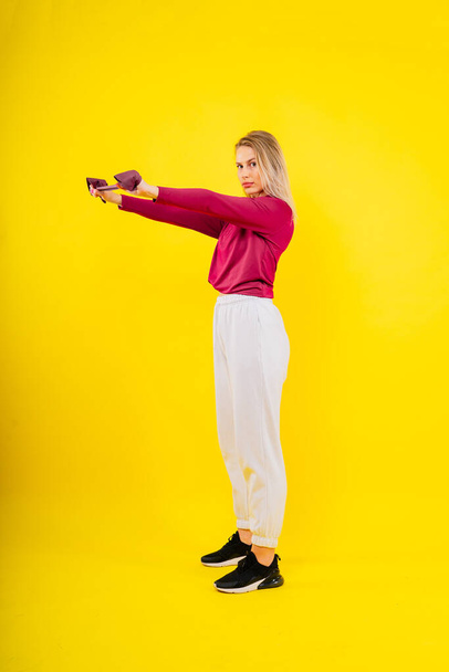 Moda spor giyim bölümünde spor yapan bir kadın stüdyoda elastik bantla egzersiz yapıyor. - Fotoğraf, Görsel