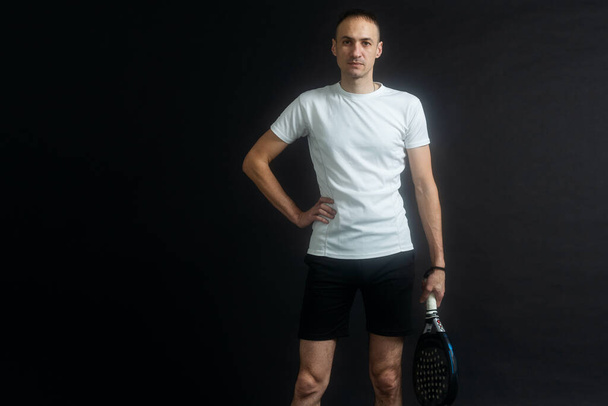 Παίκτης Padel τένις με ρακέτα στα χέρια. Αντλία τένις, σε μαύρο φόντο. Υψηλής ποιότητας φωτογραφία - Φωτογραφία, εικόνα