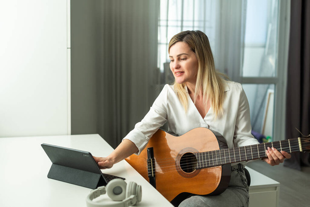  vrouw blogger live stoom spelen gitaar op sociale media. Hoge kwaliteit foto - Foto, afbeelding