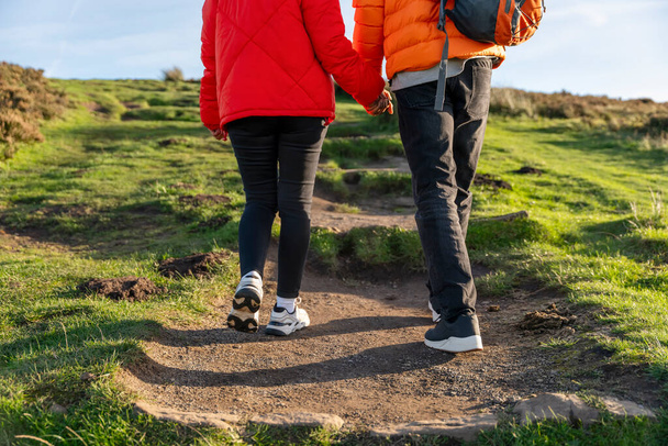 happy couple in love walking along countryside at the sunset.  Love, hiking and active lifestyle concept - Photo, Image