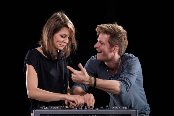 El entusiasmo del DJ masculino es contagioso, dibujando una sonrisa de la DJ femenina durante su set - Foto, imagen