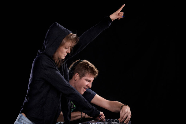 I partner DJ si sincronizzano, puntando decisamente, indicando una comprensione condivisa del flusso della musica - Foto, immagini