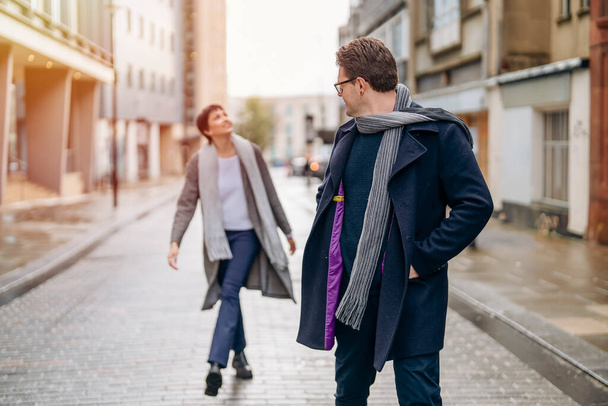 Hombre guapo y hermosa mujer abrazándose mientras caminan por la ciudad, divirtiéndose, foto de estilo de vida - Foto, imagen