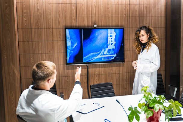 Медицинская команда изучает рентген позвоночника на цифровом мониторе - Фото, изображение