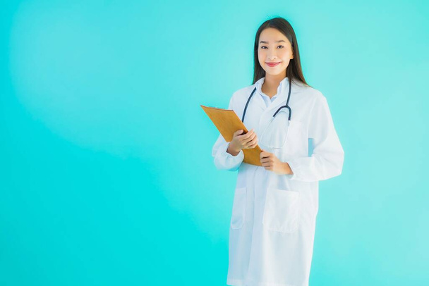 Portrait belle jeune asiatique médecin femme avec carte vide panneau d'affichage bannière sur fond bleu isolé
 - Photo, image