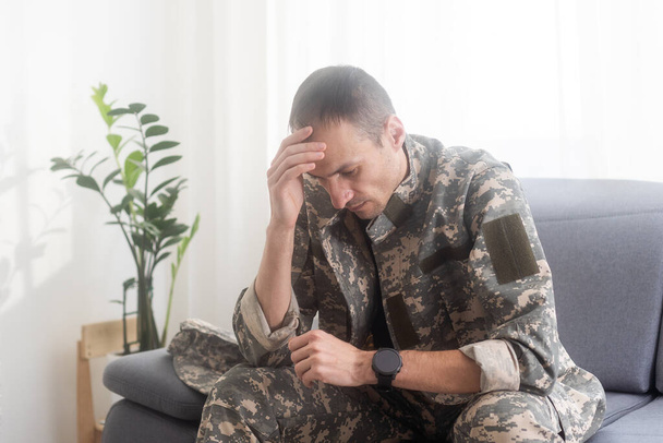 Λυπημένος στρατιώτης με στολή προσεύχεται και κάθεται. Υψηλής ποιότητας φωτογραφία - Φωτογραφία, εικόνα