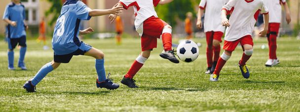 Fußball-Jugendmannschaften spielen Outdoor-Turnier. Wettbewerb für junge Fußballer. Jungen kicken Fußball. Fußballstadion im Hintergrund - Foto, Bild