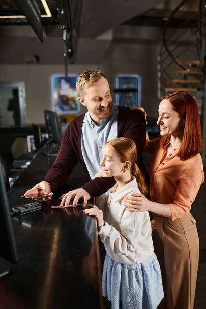 familia se involucra con una computadora, compartiendo sonrisas y risas en un momento de vinculación. - Foto, imagen