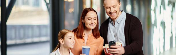 rodina stojí při sobě, sdílejí okamžik radosti a sounáležitosti v kině. - Fotografie, Obrázek
