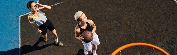 Kadınlar güneşli bir yaz gününde açık hava sahasında yoğun bir basketbol oyunu oynarlar.. - Fotoğraf, Görsel
