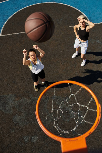 Спортивные женщины побеждают на баскетбольной площадке в летнем поединке. - Фото, изображение