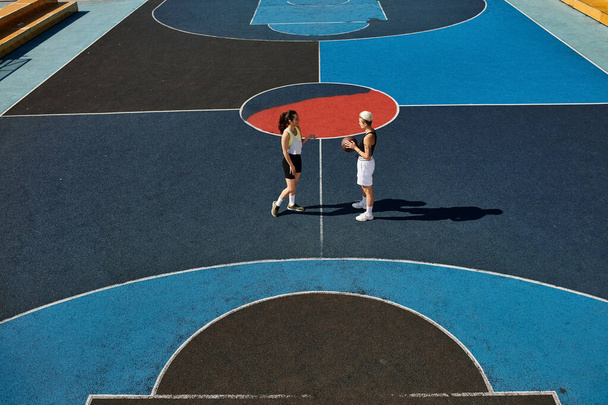 Młode kobiety umiejętnie grają w koszykówkę na dworze na świeżym powietrzu, pokazując latem swój atletyzm i przyjaźń. - Zdjęcie, obraz