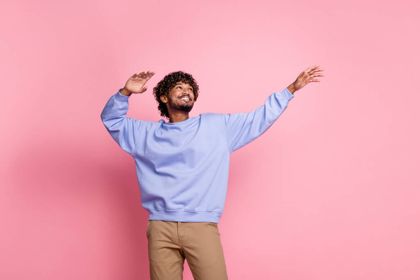 Photo of cheerful funny man dancer wear blue stylish sweater celebrate party look up empty space isolated on pink color background. - Foto, Bild