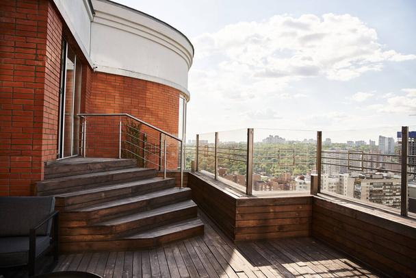 Balkon zapewnia zapierający dech w piersiach widok na krajobraz miasta poniżej, pokazując tętniące życiem miejskim i drapacze chmur - Zdjęcie, obraz