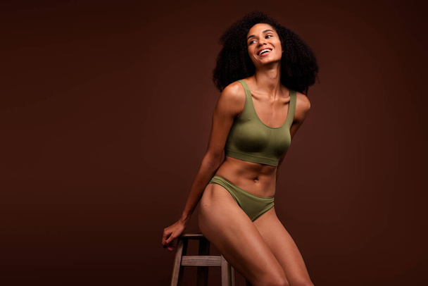 No filter photo of cheerful gorgeous woman wear khaki fashion top panties sporty muscular flawless body isolated over brown color background. - Fotó, kép