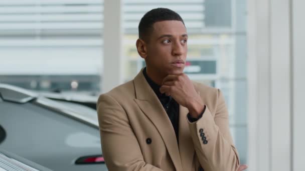 Afro-Amerikalı etnik adam düşünceli düşünceli erkek işadamı derin düşüncelere dalmış, derin düşüncelere dalmış araba tamirhanesinde yeni bir otomobil seçmiş şüpheli müşteri alıcısı. - Video, Çekim