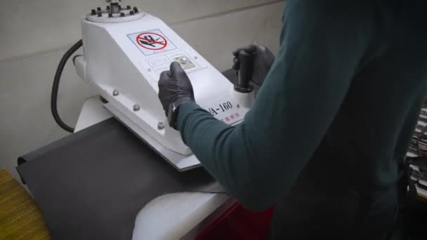 Υπάλληλος κόβει τεχνητό δέρμα με μηχανή τύπου - Πλάνα, βίντεο