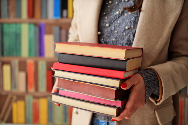 стопка книг на деревянном столе в библиотеке, Самые красивые и лучшие книги известных мировых писателей - Фото, изображение
