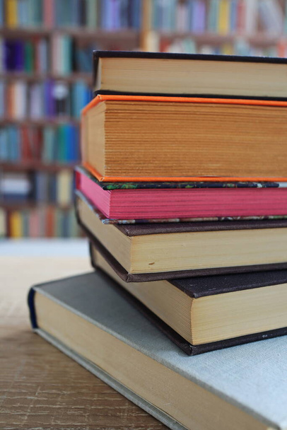 pila de libros sobre mesa de madera en la biblioteca, los más bellos y mejores libros de famosos escritores del mundo - Foto, Imagen