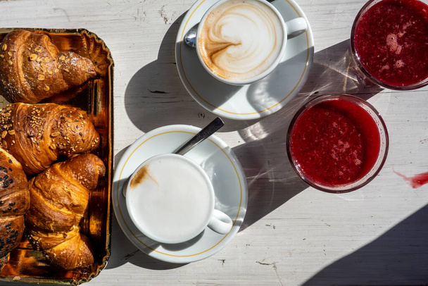 Raiano, Włochy Stolik ze świeżymi rogalikami, cappucino i świeżo wyciśniętym sokiem z pomarańczy na stoliku kawiarni. - Zdjęcie, obraz
