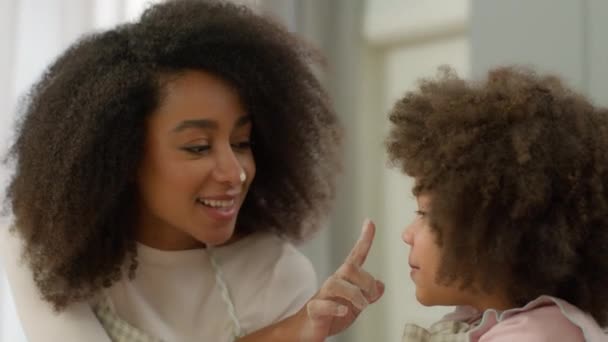 Glückliche Familie zu Hause Küche Kochen zusammen afroamerikanische Mutter mit Kind kleine Mädchen lehren Tochter Köchin spielen Berührung Nase mit Finger schmutzigen Mehlstaub Gesicht Backen Dessert lustig Witz lachen - Filmmaterial, Video