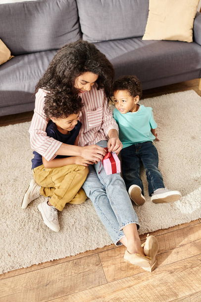 cheerful appealing african american woman spending time with her kids with present, Mothers day - Foto, imagen