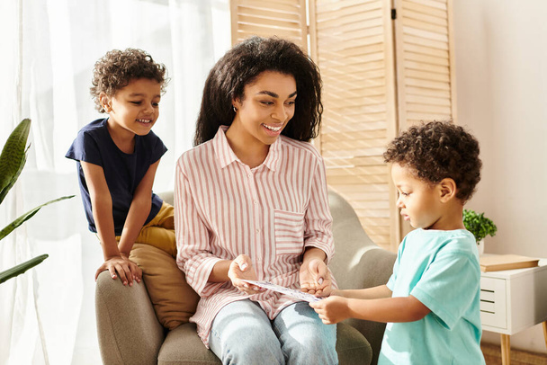alegre atraente mulher afro-americana recebendo cartão postal de seus filhos pequenos para o dia das mães - Foto, Imagem
