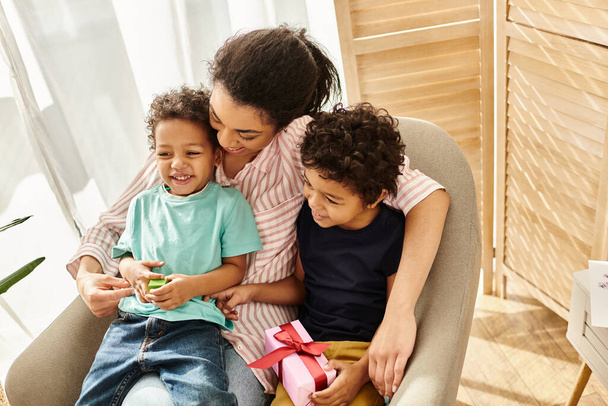 Üç çocuklu neşeli Afro-Amerikan ailesi birlikte vakit geçiriyorlar, Anneler Günü 'nde. - Fotoğraf, Görsel