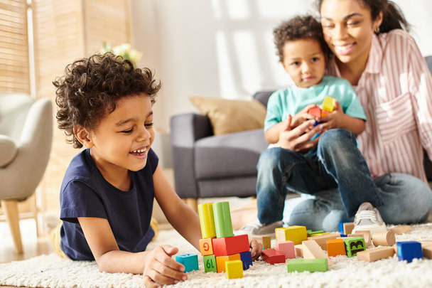 зосередитися на радісному афроамериканському хлопчику, який грає зі своєю розмитою матір'ю та братом на фоні - Фото, зображення