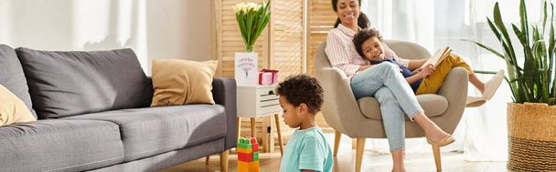 little african american boy playing with toys with her mother and brother on background, banner - Foto, immagini