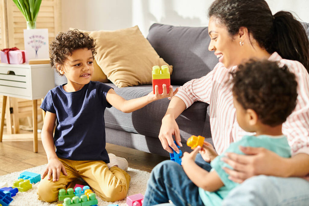 joyous african american mother in cozy homewear having great time with her little sons at home - Foto, Bild